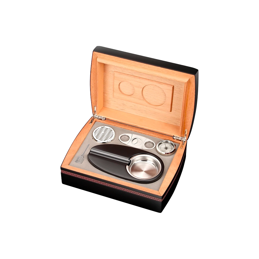 Cave à cigares portable ouverte avec les accessoires inclus disposés à plat : hygromètre, humidificateur, cendrier et coupe-cigare.