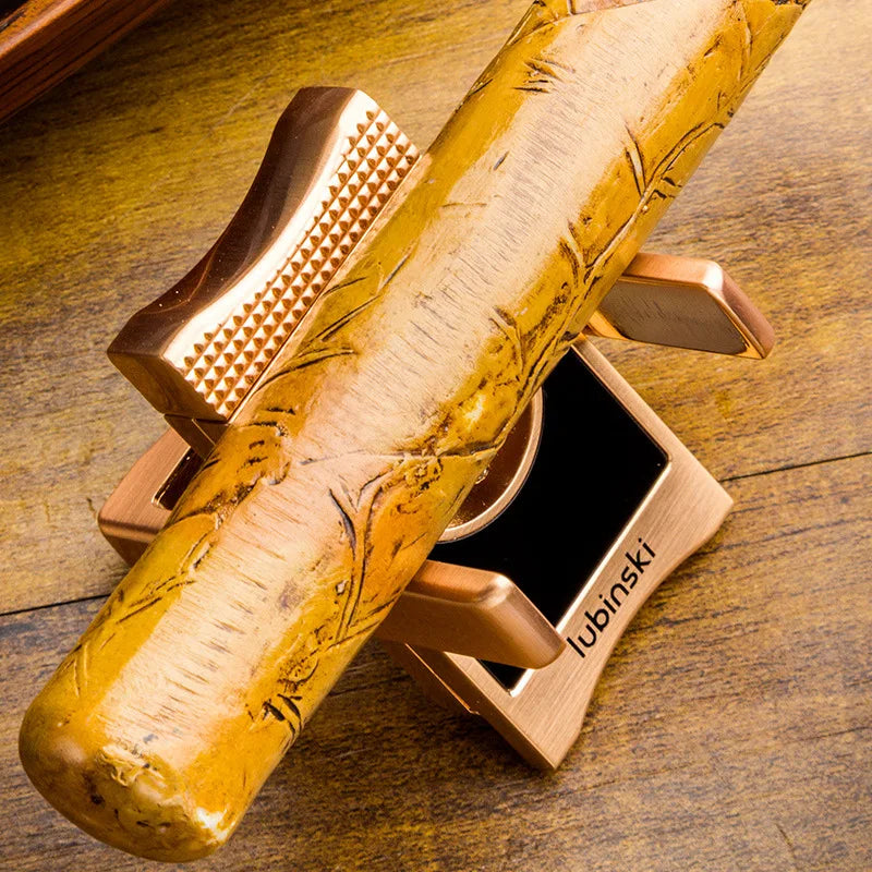 Coupe-cigare en V multifonction en zinc et acier inoxydable, coloris or, avec support intégré portant un cigare.